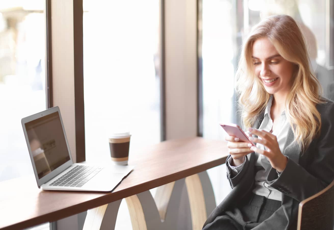 Professional young woman in cafe using mobile phone