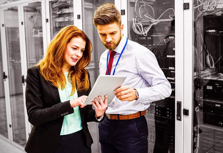 Technicians using digital tablet while analyzing server