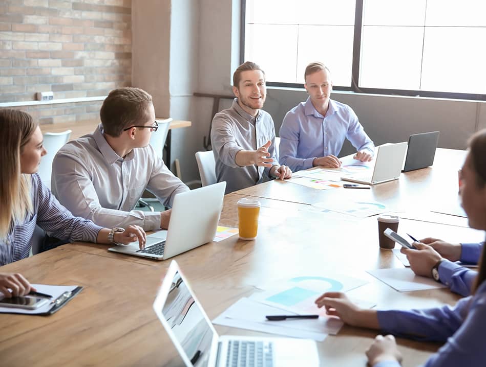 business meeting around conference table with laptops