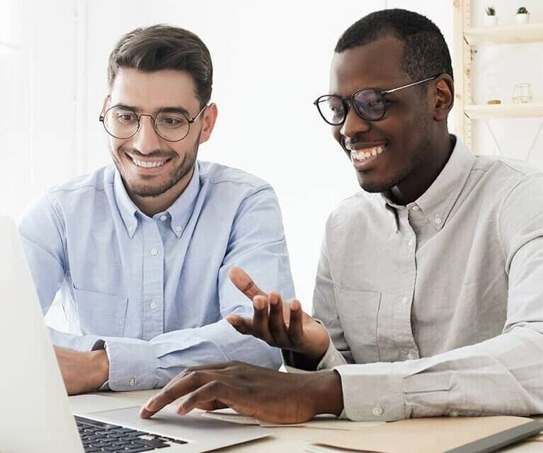 businessmen looking at laptop screen in white office
